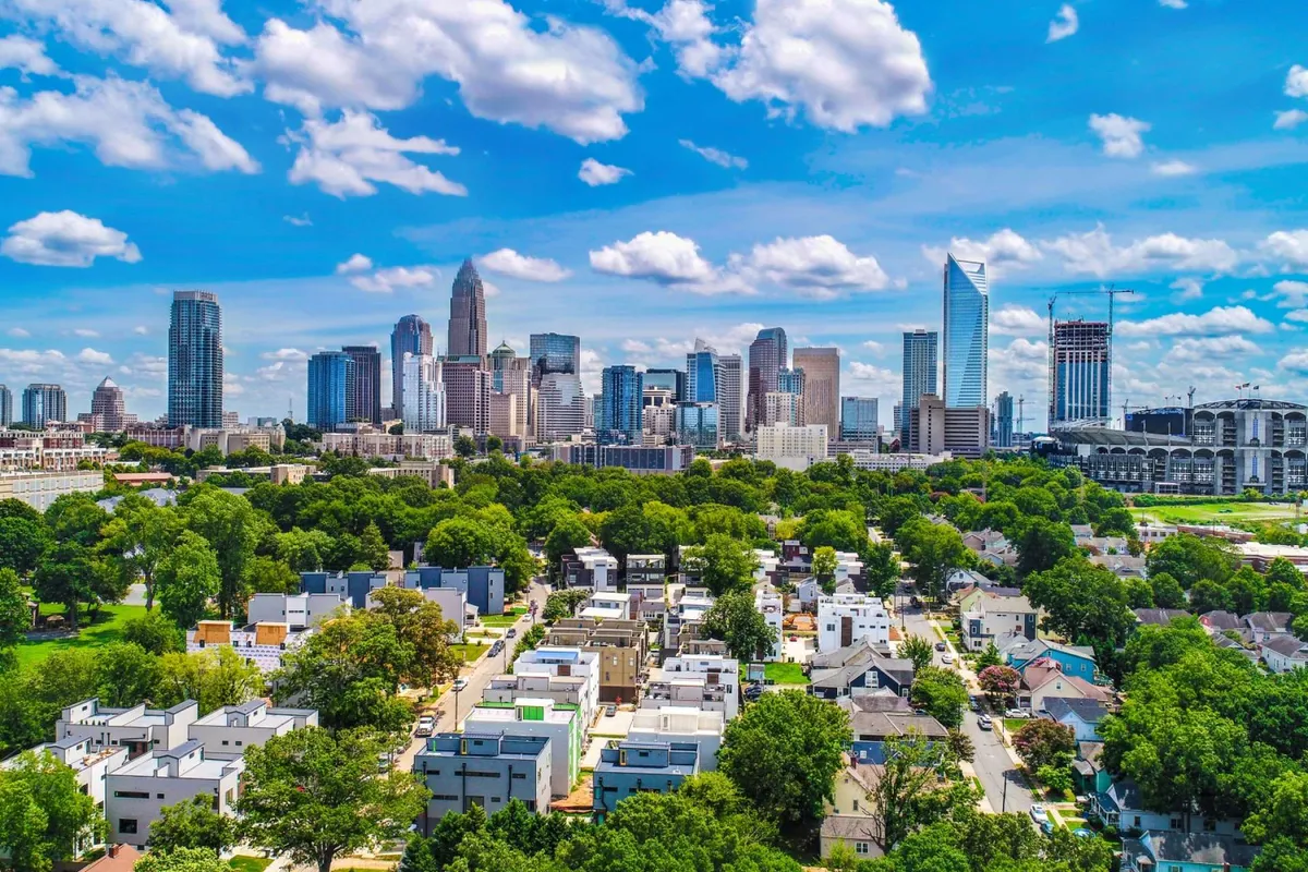 A vibrant cityscape view featuring the downtown skyline, a lush green park in the foreground, and residential blocks nearby. The open park space and city backdrop evoke a sense of adventure and provide context for local exploration and family outings.